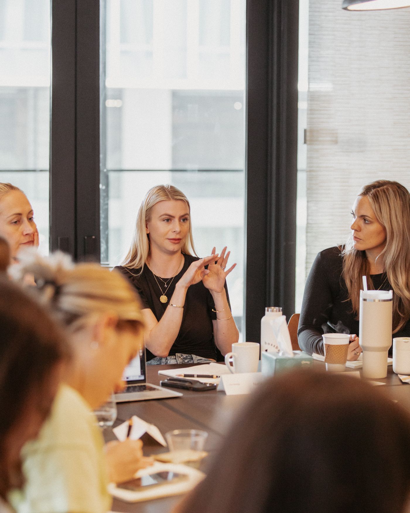 Natalie Ellis in conversation with women around a conference table